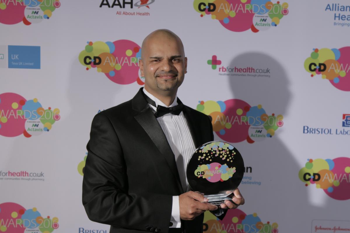 A man in a tuxedo holding an award