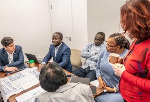 A group of people sitting around a table looking like they are discussing and talking