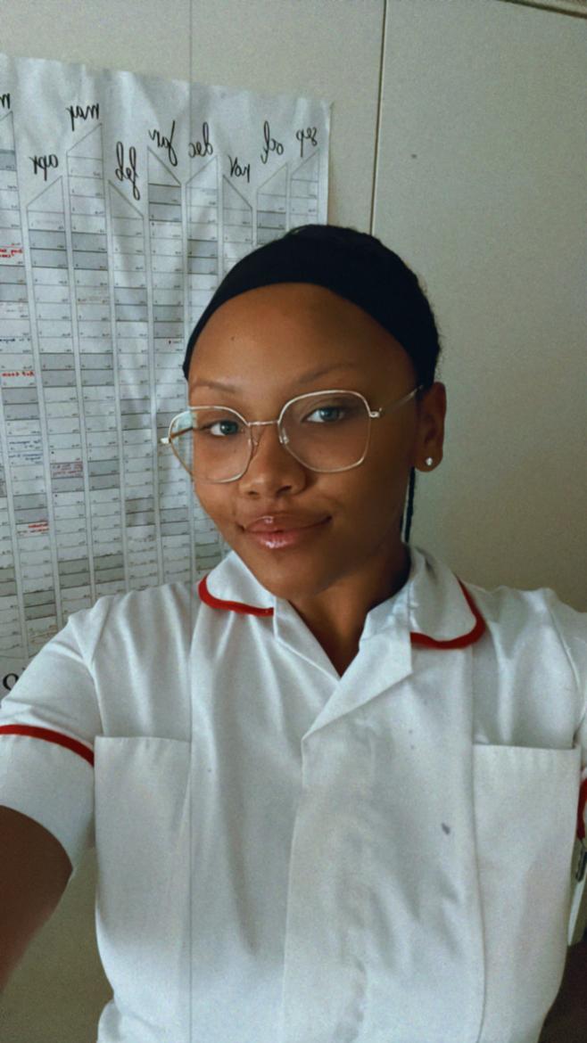 A women smiling at the camera wearing her student nurse uniform