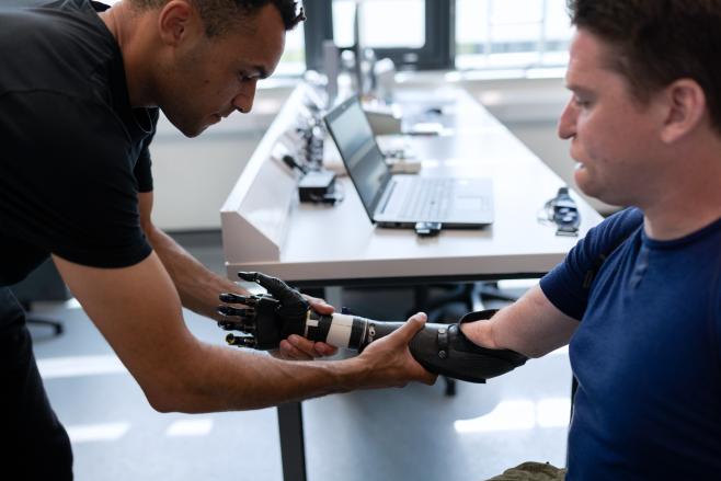 Picture of two men, one with a bionic arm. Copyright of © This is Engineering